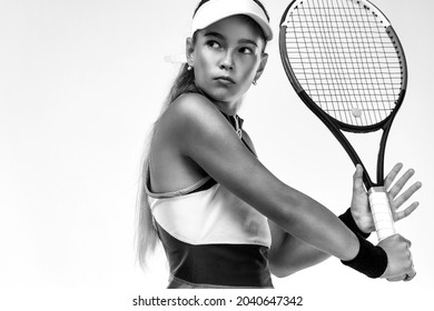 Tennis speler. Mooie meisjestiener en atleet met racket in roze sporswear en hoed op tennisbaan. Sportconcept.