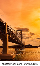 Puente Naruto Kaikyo Ohashi en el fondo del cielo de color naranja al atardecer