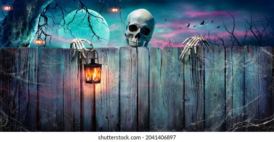 Halloween - Skelett, das Laterne auf hölzernem Banner in der gruseligen Nacht hält