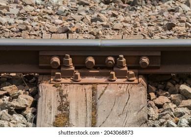 Ferrocarril de acero, traviesas de ferrocarril, pernos y tuercas oxidados en rieles de ferrocarril. Construcción de una línea ferroviaria