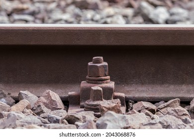 Ferrocarril de acero, traviesas de ferrocarril, pernos y tuercas oxidados en rieles de ferrocarril. Construcción de una línea ferroviaria