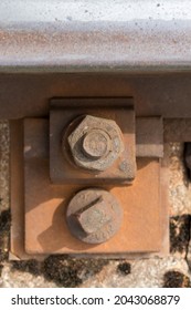 Ferrocarril de acero, traviesas de ferrocarril, pernos y tuercas oxidados en rieles de ferrocarril. Construcción de una línea ferroviaria