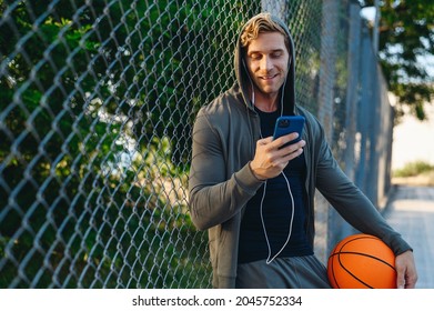 Esportivo com bola para jogar basquete, ouvindo música em fones