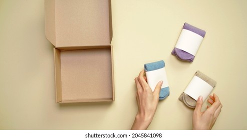 Hand einer Frau, die Socken in eine Kiste räumt