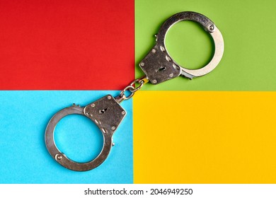有名なコンピューター企業の色の紙に手錠をかけ、サイバー犯罪者がコンセプトを捉えた。ソフトウェア株式会社のロゴ。赤、緑、青、黄の紙の色。抽象的な背景。