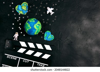 Tabelë me duartrokitje filmash me glob, astronaut dhe yje në sfond të zi. Koncepti i filmit të kinemasë hapësinore me hapësirë ​​kopjimi për tekst.