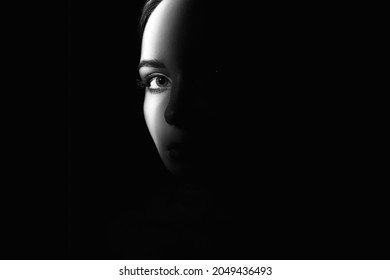 retrato en blanco y negro de un hermoso ojo de niña. parte de la cara de una mujer bastante joven en la oscuridad