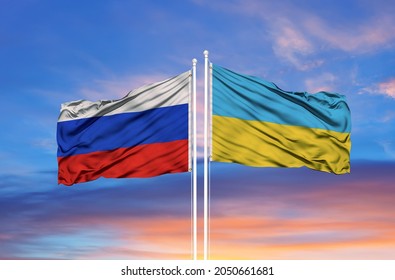 Oekraïne en Rusland twee vlaggen op vlaggenmasten en blauwe lucht