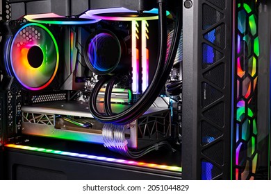 Inside view of black high end custom colorful illuminated bright rainbow RGB LED gaming pc. Computer power hardware and technology concept background