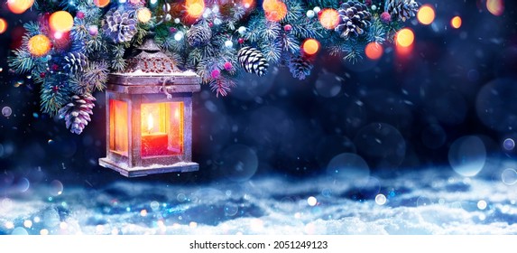 Weihnachtslaterne in der Nacht mit Schnee und Tannenzweig