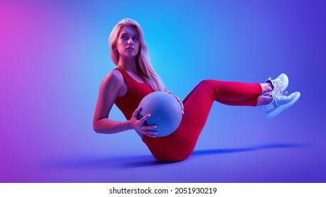 Pelatihan wanita sporty kaukasia dengan bola kebugaran. Potret konsep sporty cahaya neon kebugaran model wanita kebugaran dengan latar belakang gaya abstrak. Konsep perawatan kesehatan. Gaya hidup sehat.