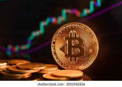 Bitcoin and cryptocurrency investing concept. Bitcoin cryptocurrency gold coin. Trading on the cryptocurrency exchange. Trends in bitcoin exchange rates. Rise and fall charts of bitcoin.
