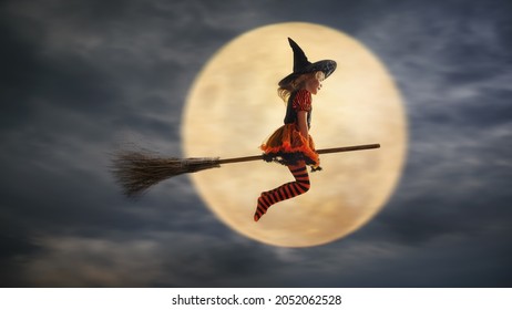 子供は月を背景にハロウィンに魔女として飛ぶ