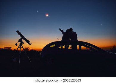Cặp đôi cùng nhau ngắm sao bằng kính viễn vọng thiên văn.