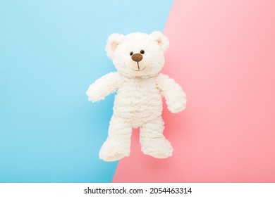 Lachende witte teddybeer op licht roze blauwe tafel achtergrond. Pastelkleur. Detailopname. Beste vriend van kinderen.