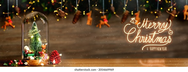 Frohe Weihnachten und guten Rutsch ins neue Jahr Weihnachtsbaum und Weihnachtsmann im Glaskuppeldekor mit Flitterren, Kiefernkegellametta am hölzernen Hintergrund