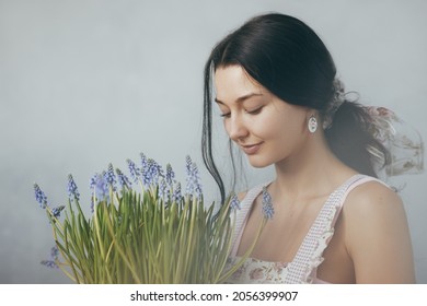 Frau mit Blumenstrauß in den Händen drinnen