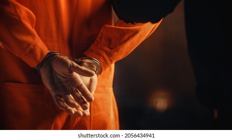 法と正義の裁判所の裁判で逮捕された手錠をかけられた囚人。オレンジ色の刑務所のジャンプ スーツを着た被告人に手錠をかけられています。法律違反者は懲役刑を言い渡されました。