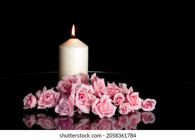 LUMANARE ALUMINATA SI ARANJAMENT ELEGANT DE TRADAFIRI ROZ PE FOND INCHIS. FELICITĂ DE CONDOLEAȚE, ZIUA TUTUROR SUFLETELOR, MOARTE, DECES, ZI MEMORIAL, DUEL, DOLI, MORMANT, CIMITIR, INCERNARE, ÎNMORMARE ȘI ÎNMORMARE.