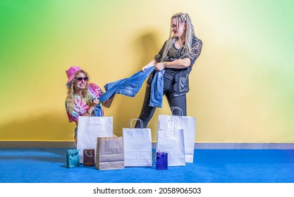 二人の若い女性客がズボンをめぐって争っている お互いの手からジーンズを奪おうとしている 目の前には買い物袋がある