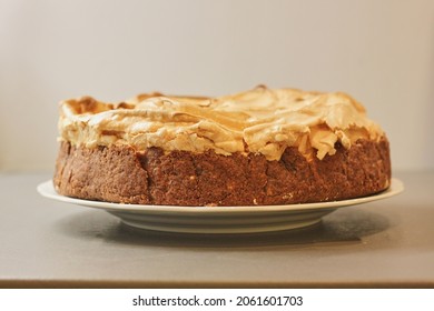 Delicious homemade cake with meringue and apple on grey background and with slight sepia effect. High quality photo