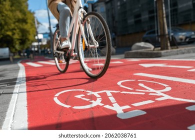 交通、都市交通、人々 のコンセプト - 路上で自転車の兆候と赤い自転車レーンに沿ってサイクリングの女性