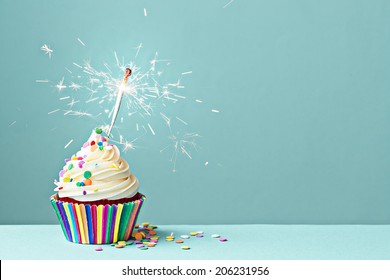 カラフルなスプリンクルと線香花火で飾られたカップケーキ