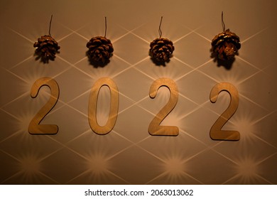Happy New Year 2022. Number 2022 is made of wood on a wooden background. Christmas background with fir branches. ECO decorations. Banner