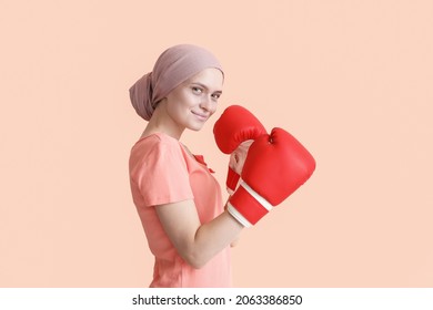 色の背景にボクシング グローブでの化学療法後の女性。がんと闘う