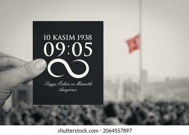 Hand hält Papier mit Nachricht, Todesstunde und Datum von Atatürk über Menschenmenge und türkische Flagge, die am 10. November in Anitkabir auf Halbmast weht. Deutsch: Wir gedenken deiner mit Respekt und Sehnsucht.