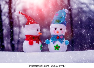 Người tuyết trong khu rừng mùa đông trong một trận tuyết rơi. Thiệp chúc mừng Giáng sinh và Năm mới với người tuyết
