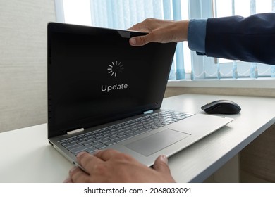 Updating Software Technology Upgrade Concept. a businessman opens a modern ultrabook on which the operating system is being updated.