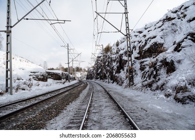 鉄道は岩の間を通り抜けます。雪に覆われた鉄のドーガ。冬の雪の中、蒸気機関車からスータ。雪の中のレール。