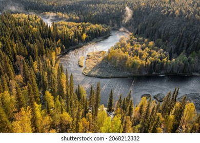 Paisaje otoñal en el Parque Nacional de Oulanka al amanecer en Finlandia. Hermoso río en un bosque de pinos en el norte de Finlandia. Bosque cubierto con la primera nieve