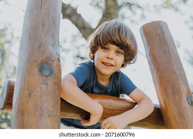 portrait of a smiling little brunette boy in a blue T-shirt playing outdoors. happy child, lifestyle. products for children. High quality photo