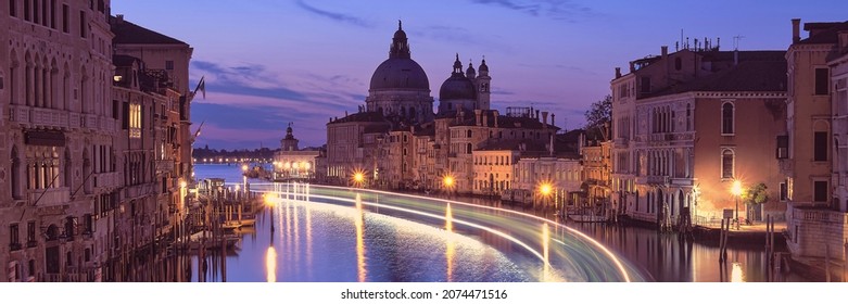 Venice lãng mạn về đêm. Hình ảnh cảnh quan thành phố của Kênh đào Grand ở Venice, với Vương cung thánh đường Santa Maria della Salute phản chiếu trong làn nước biển lặng. Đèn của thuyền chở khách trên mặt nước.