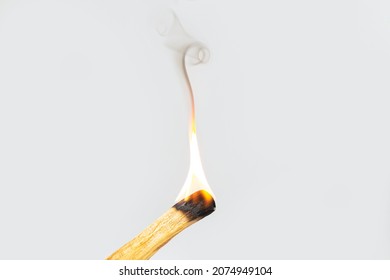 Palo santo or holy wood incense stick burning with flame and aromatic smoke. Cleansing negative energy concept