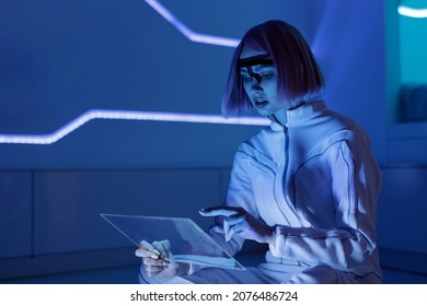 手裡拿著未來式平板電腦的女人。虛擬實境眼鏡中的女孩。擴增實境、未來科技、人工智慧概念。全像介面顯示數據。智慧家庭背景。