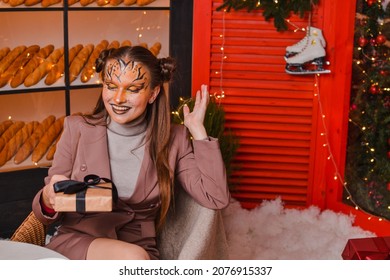 虎の化粧をした美少女がプレゼントを喜ぶ。新年のコンセプト。虎の年
