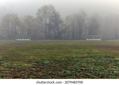 Bancos de reemplazo en el campo de fútbol en otoño en la niebla