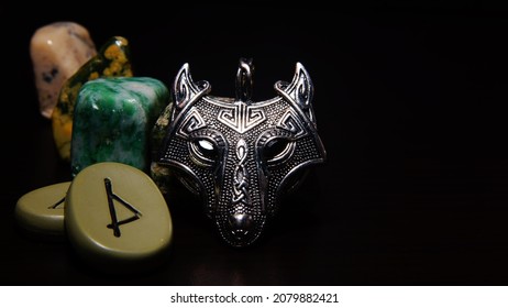 Vikingen zilveren amulet wolfskop, runen, halfedelstenen in het donker. Mystieke achtergrond