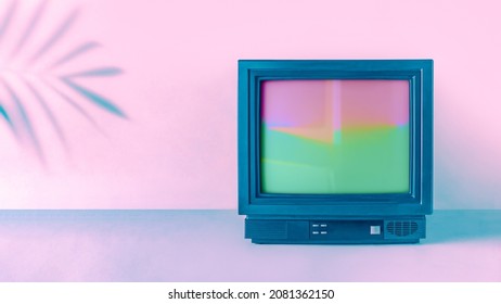 Concept de mode vaporwave abstrait minimaliste des années 90 avec une ombre de feuille de palmier tropicale et une bordure de boîtier de télévision vintage. Fond néon rose-violet-bleu. Idée de carte rétro futuriste. Cadre réalisé avec un téléviseur.