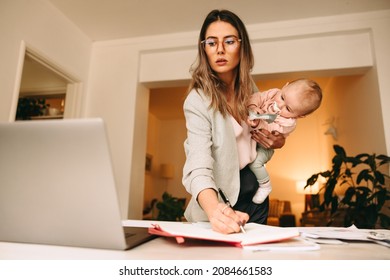 Gestalten Sie professionelle Notizen, während Sie ihr Baby halten. Multitasking-Mutter plant ein neues Projekt in ihrem Heimbüro. Kreative Geschäftsfrau, die Arbeit und Mutterschaft balanciert.