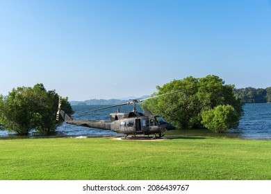 helikopter soldaat door zijaanzicht op helipad park en groen grasveld met boom onder water op meer of zee bij pom pee in khao laem nationaal park en vajiralongkorn dam op heldere blauwe lucht en daglicht