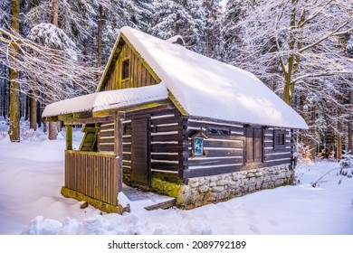 Pequeña cabaña forestal de madera en invierno