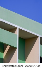 Abstracte geometrische patroonachtergrond van arcerend vinbeton op moderne groene en beige bouwmuur tegen blauwe heldere hemel in verticaal frame