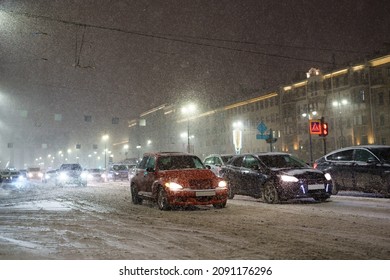 Las fuertes nevadas paralizan el tráfico de la ciudad, la carretera nevada con muchos coches apilados en atascos durante la ventisca de nieve por la noche, el tráfico colapsa en la carretera de invierno. Conducir con mal tiempo y poca visibilidad