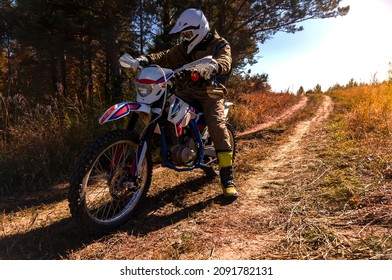 Pictured is a motorcyclist in outfit on a sunny autumn day
