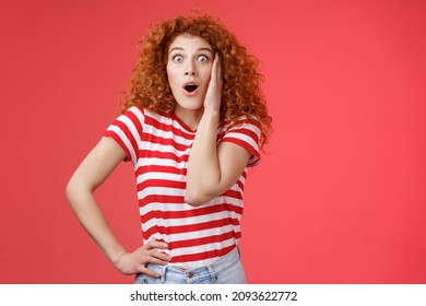 ショックを受けて 面白がって 感情的な 赤毛の生姜の女の子 巻き毛のヘアカット 飛び出る目 じっと見つめる カメラ 魅了された 感銘を受けた 口を開けて あえぎ 楽しませた 反応する 信じられないほどの店 価格のオファー 赤い背景