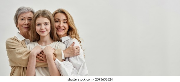 Família caucasiana sorridente de três gerações femininas se abraçando e olhando para a câmera. Conceito de idade e geração. Relacionamento familiar e proximidade. Isolado em fundo branco Sessão de estúdio. Espaço para cópia